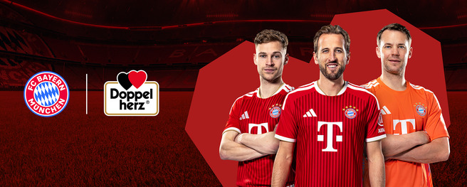 Three football players wearing red jerseys with a white logo representing FC Bayern München stand together on a grassy field. The background features a stadium atmosphere, with logos for FC Bayern München and Doppelherz displayed nearby.